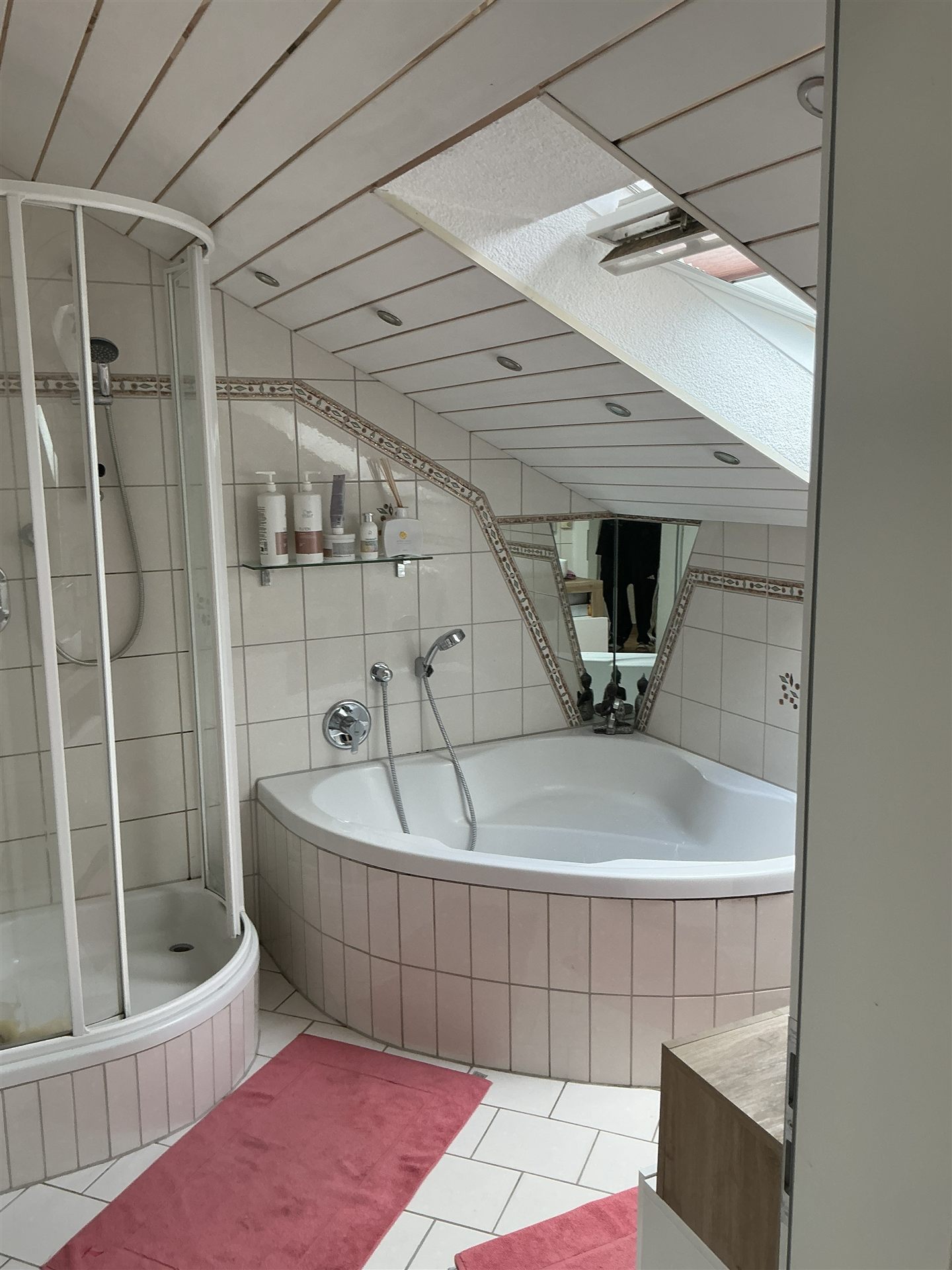 Badezimmer mit Eckbadewanne und Dachflächenfenster